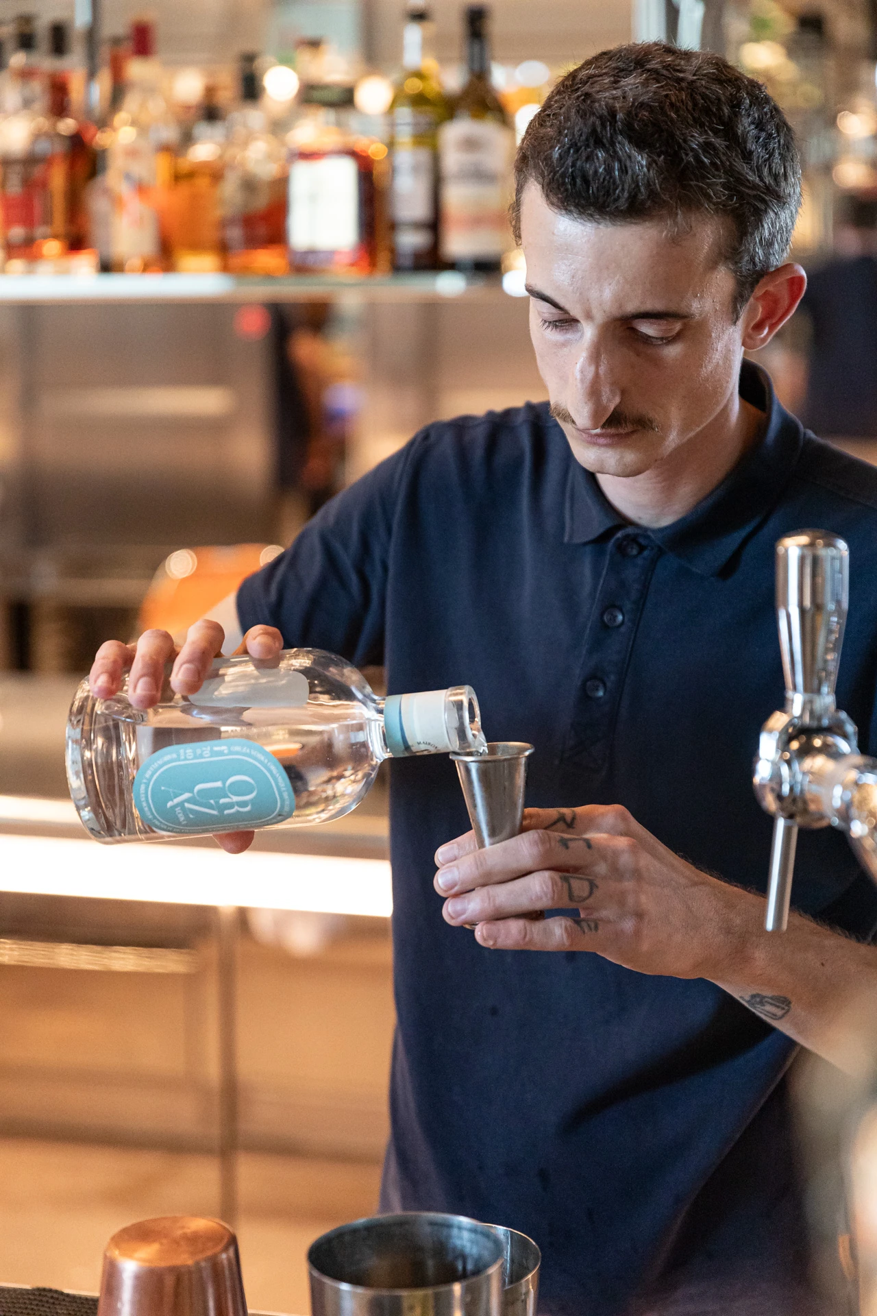 Barman tenant une bouteille pour fabriquer un cocktail.