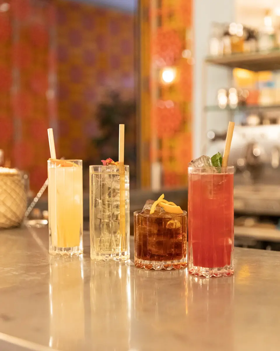 Cocktails colorés posés sur un plan de travail à L'Arlatan, hôtel, bar et restaurant à Arles