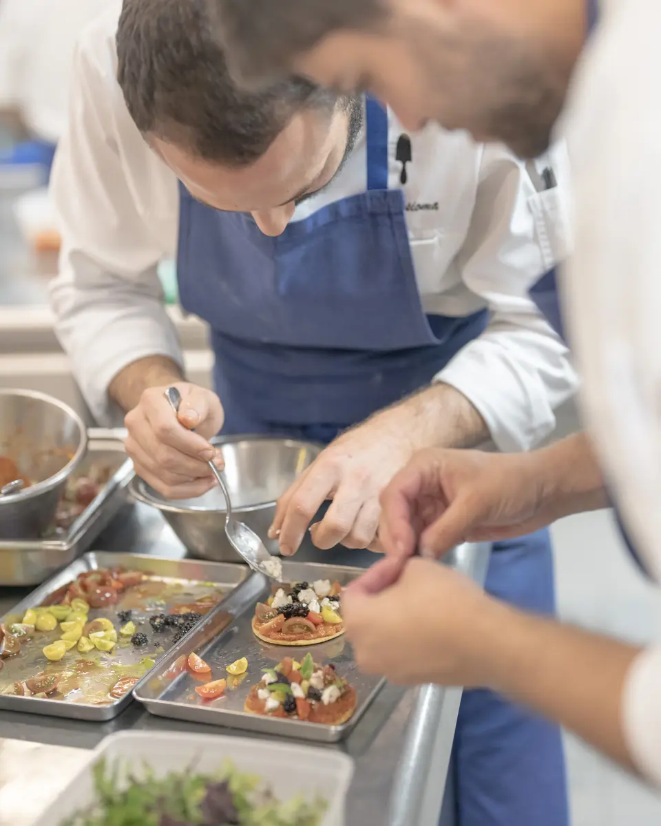 Cuisiniers qui dressent des plats sur le pass.