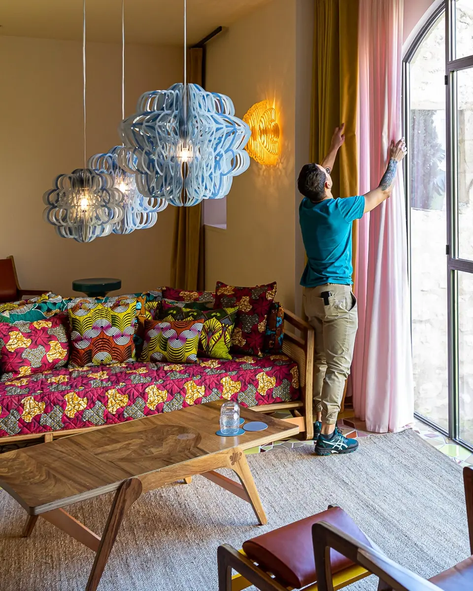 Staff arranging curtains in a room at hotel L'Arlatan