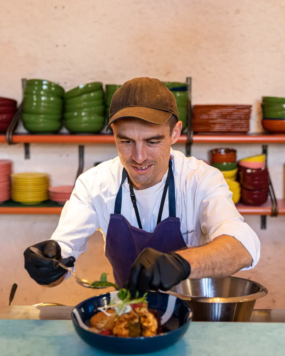 Cuisiniers qui dressent des plats sur le pass.