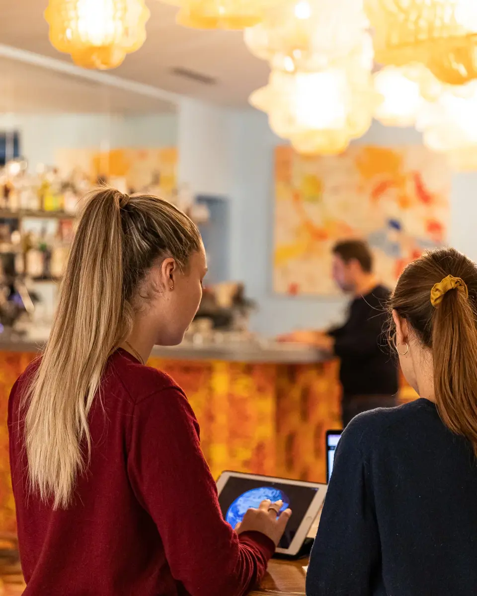 Two people discussing a topic while using a tablet